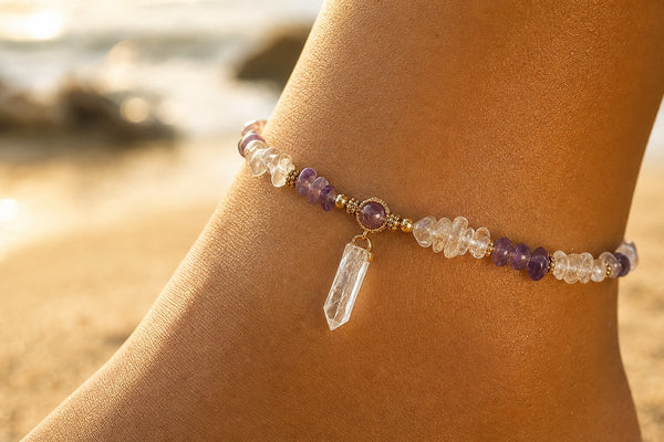 Crystal anklet with amethyst and clear quartz beads on sandy beach