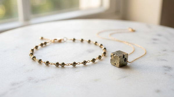 Photorealistic pyrite bracelet and pyrite cube pendant on marble